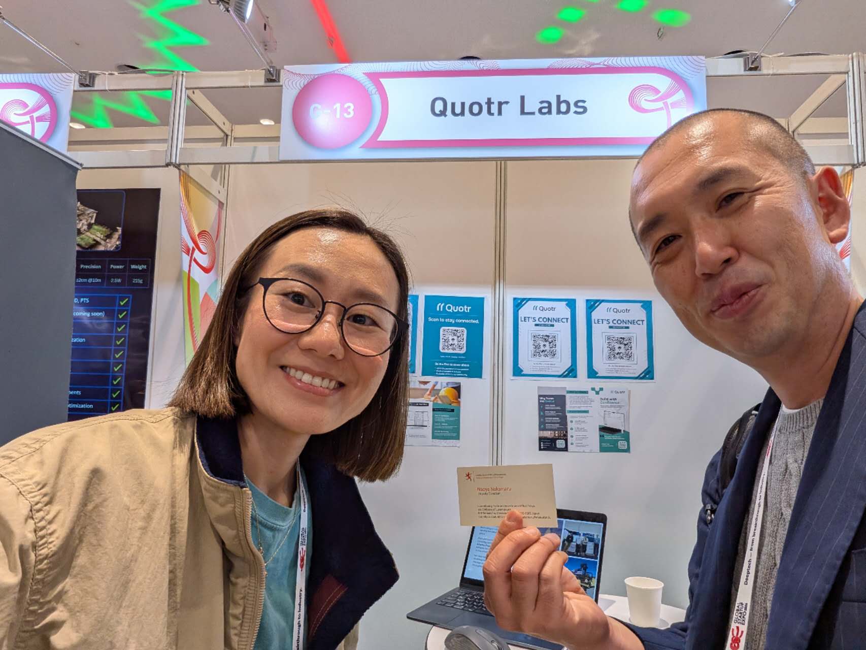 A visitor sharing a card at the Quotr Labs booth.