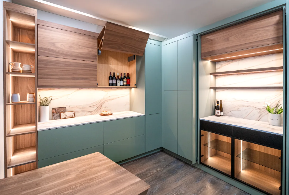 Modern kitchen cabinetry in sage green with walnut accents